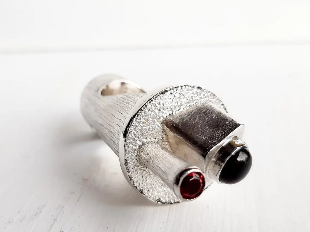 Horizontal view of Sentinel handcrafted sterling silver ring sculpture featuring black onyx and garnet
