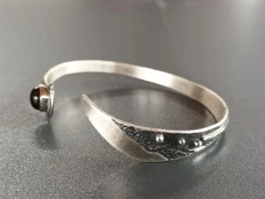 Three-quarter view of the Still Point sterling silver bracelet highlighting its sculptural form.