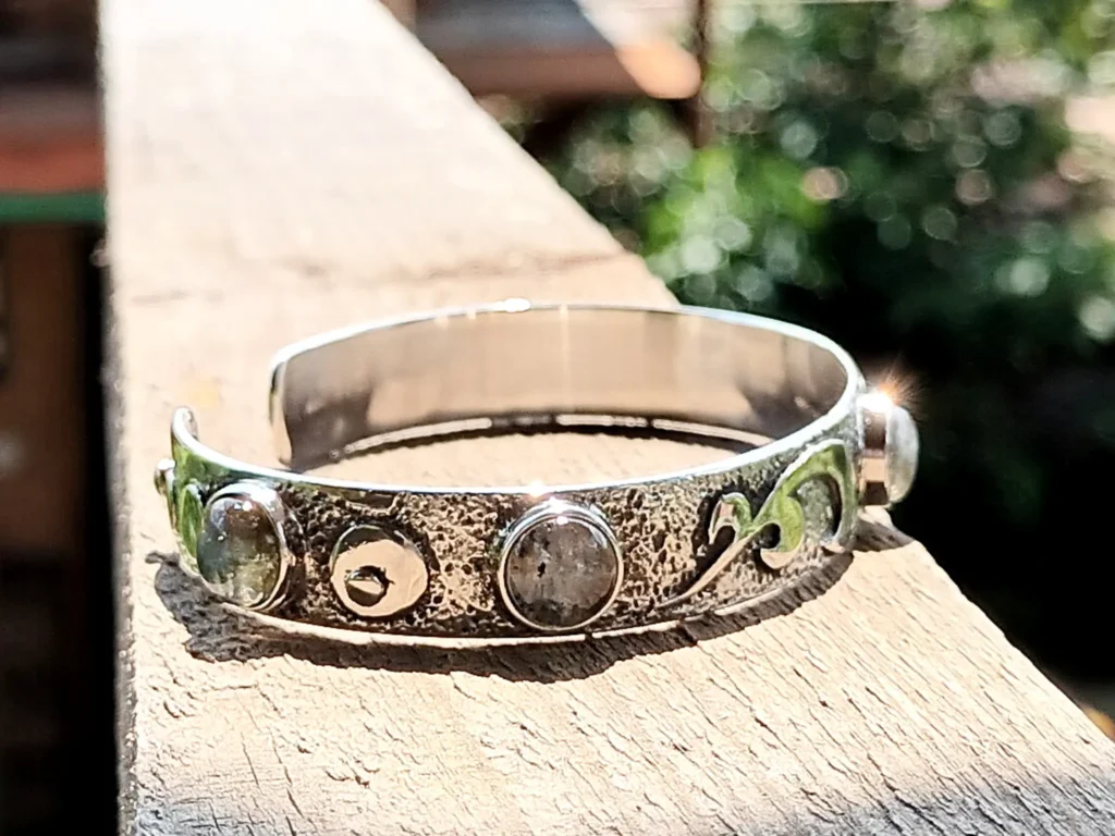 Side perspective of the Gathered handcrafted sterling silver bracelet highlighting its textured surface and gemstones.