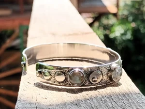 Profile view of the Gathered contemporary sterling silver bracelet highlighting the bezel-set natural gemstones and textured silver surface.